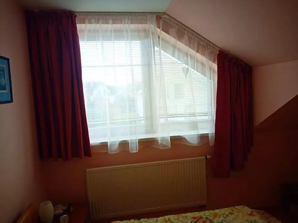 Atypické okno se záclonou a závěsem
