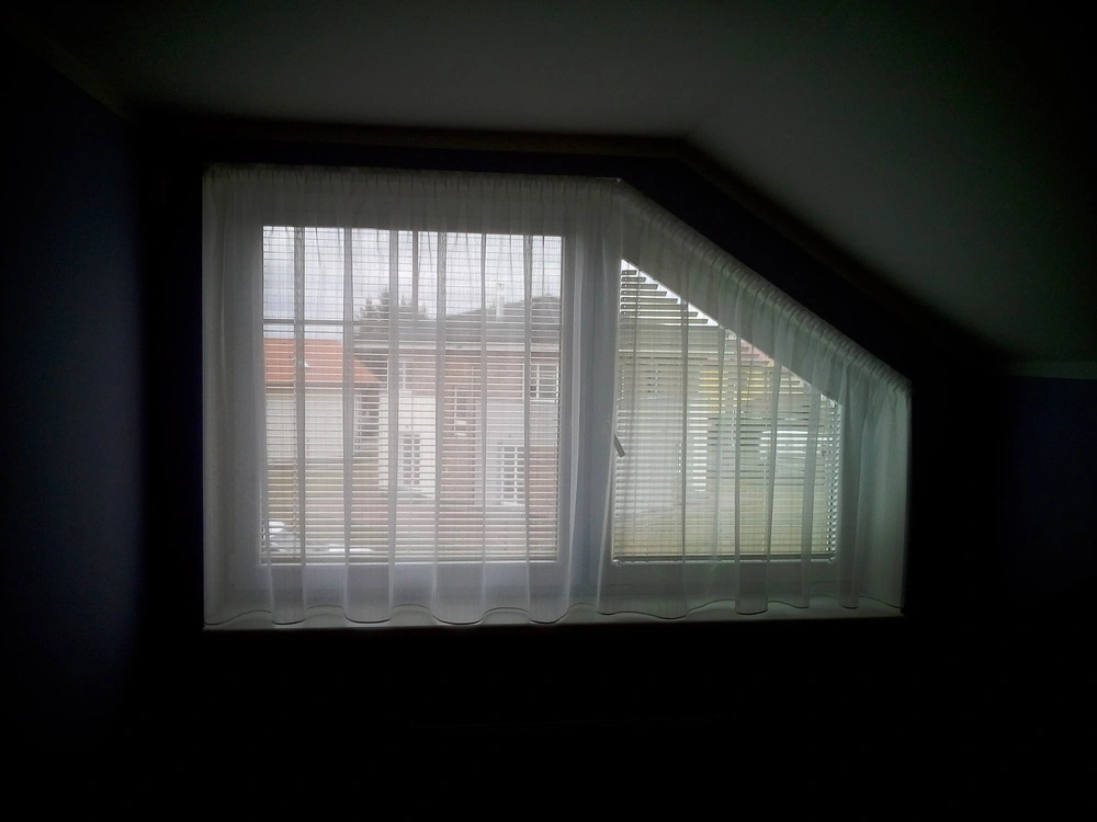 Atypické okno se záclonou a závěsem